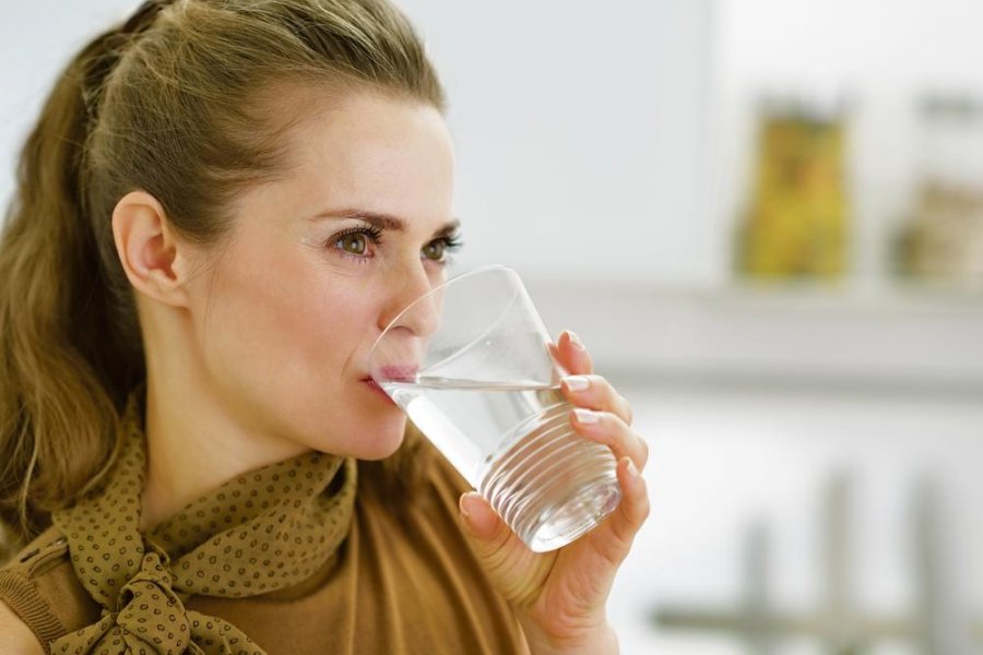 1867345stockphotoyounghousewifedrinkingwaterinkitchen149482910ls